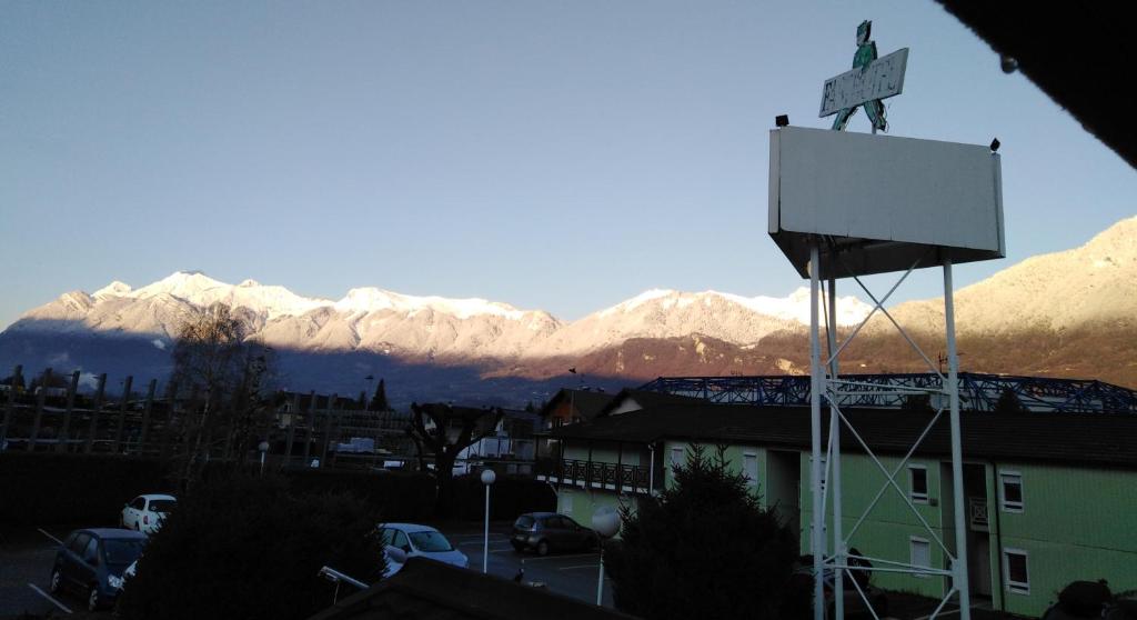 a man standing on top of a basketball hoop in front of mountains at Fasthotel Albertville in Albertville