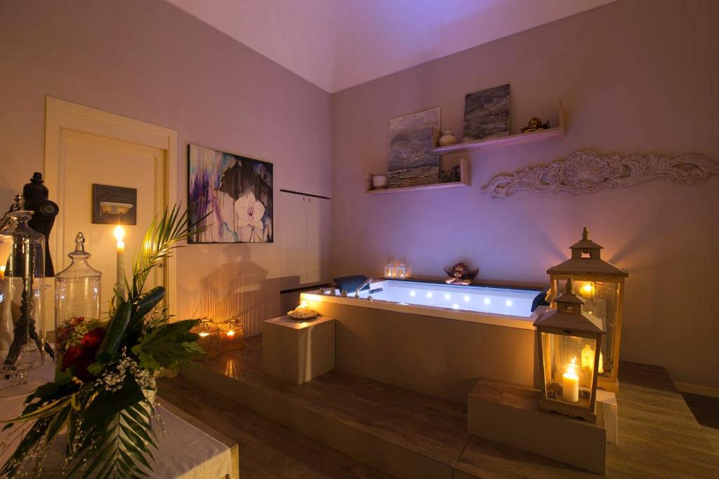 een grote badkamer met een bad met kaarsen en verlichting bij Corte Rossetti Le Dimore Luxury B&B in Vasto