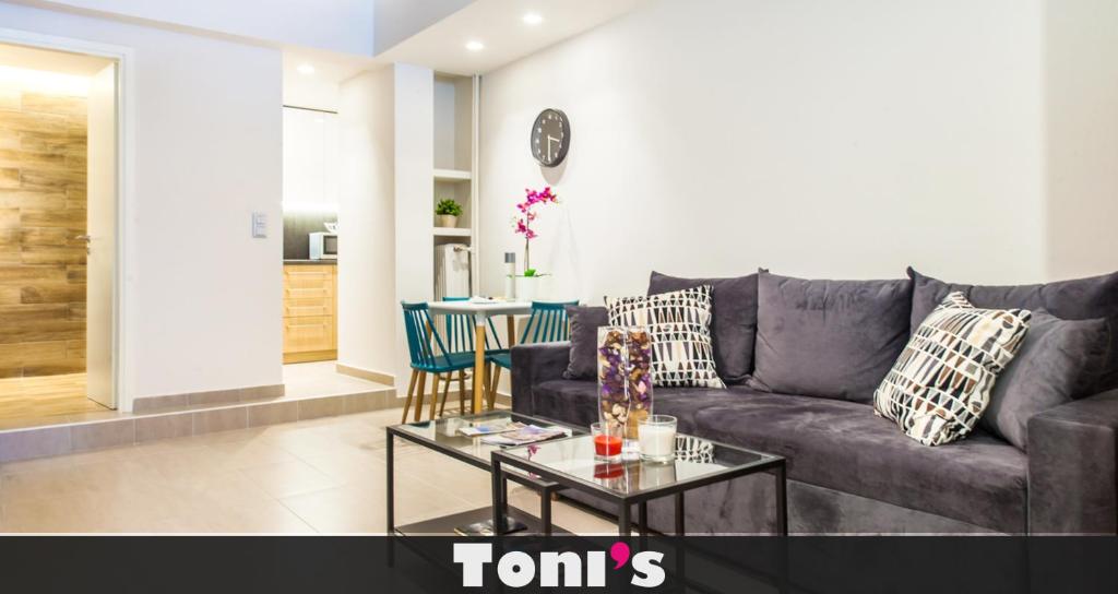 TONI'S Studio Syntagma, 1 min from Metro station في أثينا: غرفة معيشة مع أريكة وطاولة