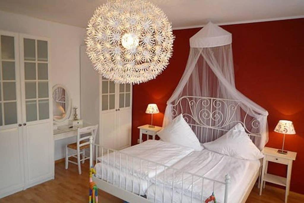 a bedroom with a large white bed with a chandelier at Refugium am Engelbecken in Berlin