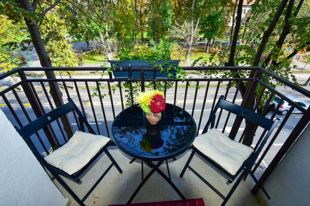 uma mesa com um vaso de flores numa varanda em Central Park Apartment em Constança