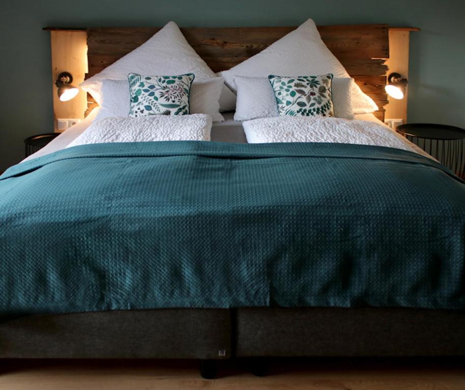 a large bed with a green comforter and pillows at Dachstein 7 in Gosau