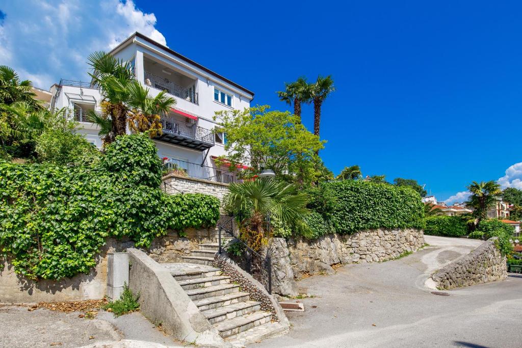 dom z kamienną ścianą i schodami w obiekcie Villa Tomić Apartment Mia near the sea w mieście Opatija