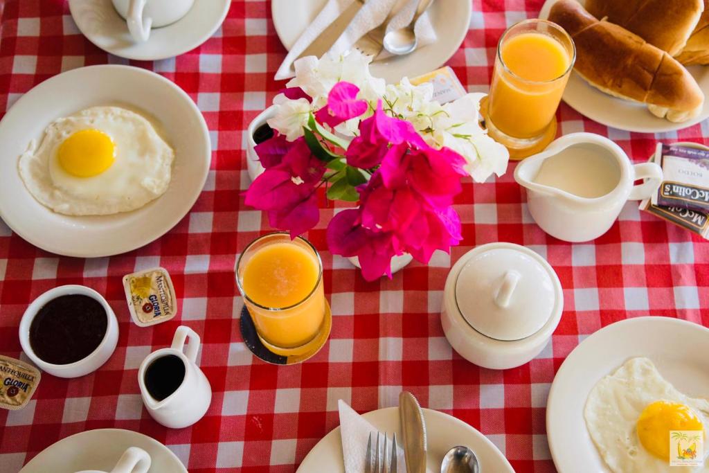 ein Frühstückstisch mit Eiern, Kaffee und Blumen in der Unterkunft Hotel Smiling Crab in Canoas De Punta Sal