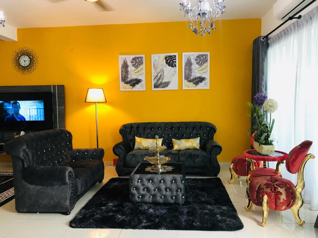 a living room with a black couch and yellow walls at D'Tempat in Kampong Baharu Jimah