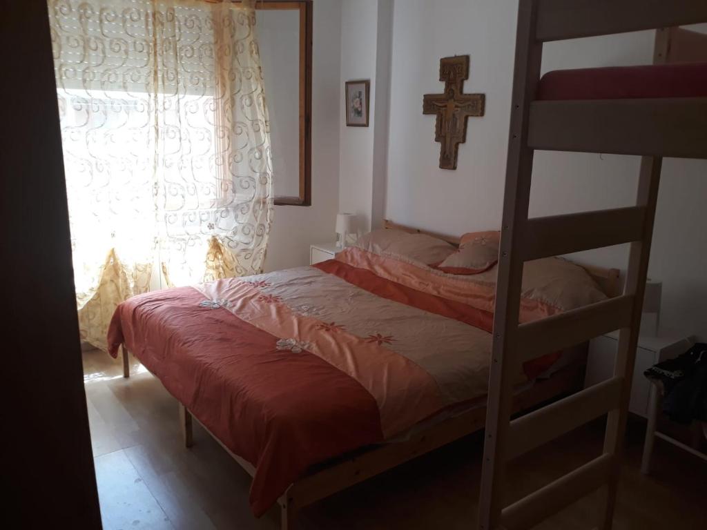 um quarto com um beliche e uma cruz na parede em Casa al mare em Lido di Fermo