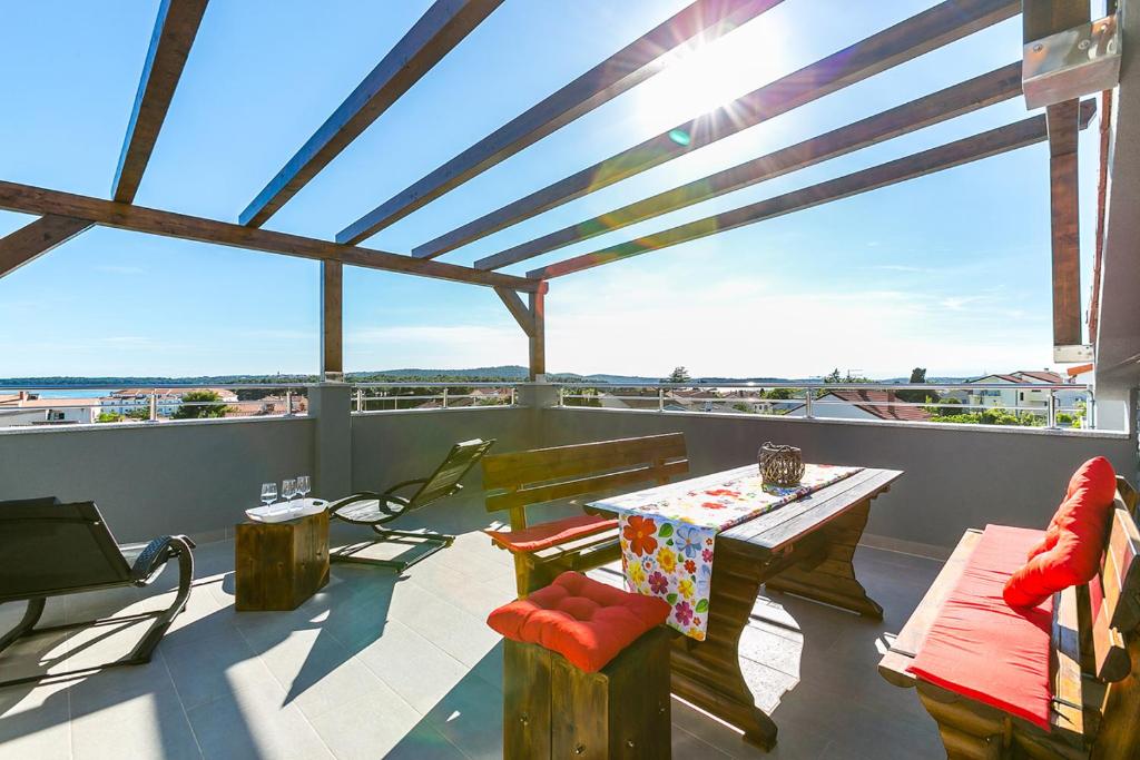 eine Terrasse mit einem Tisch und Stühlen auf dem Balkon in der Unterkunft Istriensonne 0146 - Tess mit Meerblick in Medulin