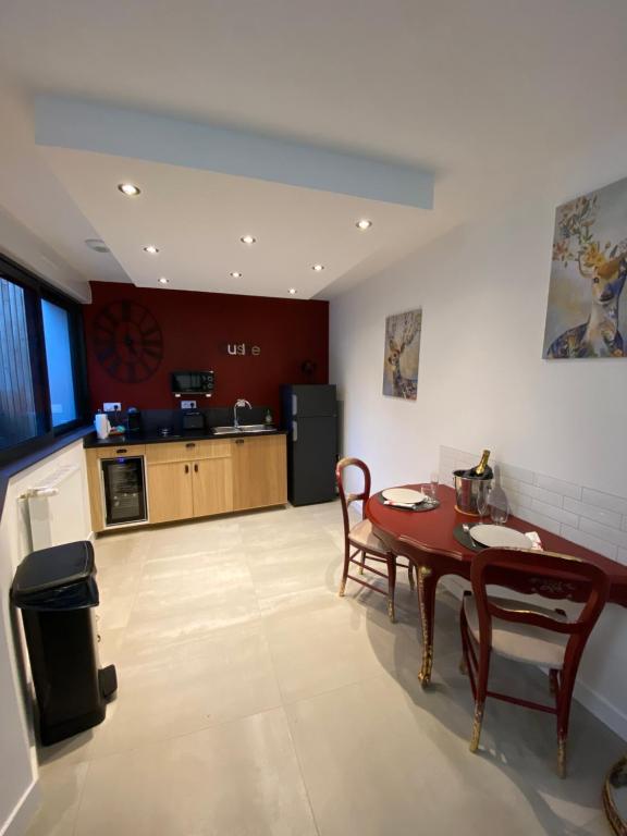 a living room with a table and a kitchen at Les Suites de Bougainville in Concarneau