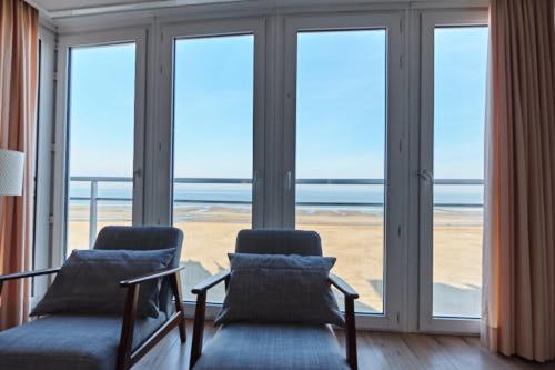 - un salon avec deux chaises et une grande fenêtre dans l'établissement Seascape, à Ostende