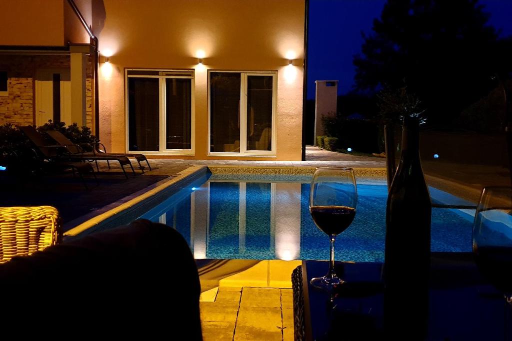 een glas wijn naast een zwembad bij Villa Nemo in Poreč