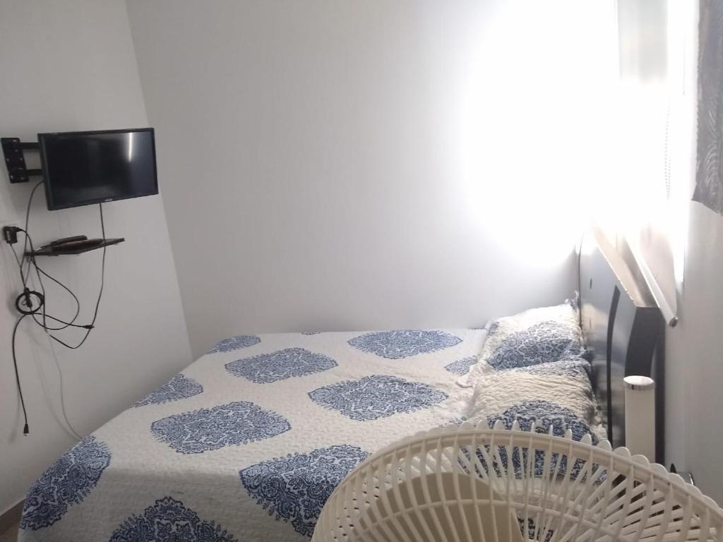 1 dormitorio con 1 cama con edredón azul y blanco en apartaestudio parejas 10 mnts del terminal, centro de eventos valle del pacifico y del centro de la ciudad, salida al aeropuerto, en Cali
