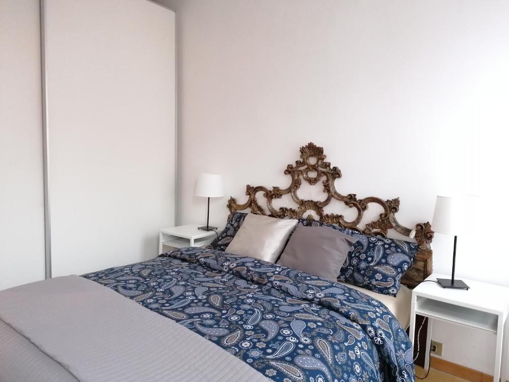 a bedroom with a bed with blue and white sheets and pillows at Casa Palazzi in Venice