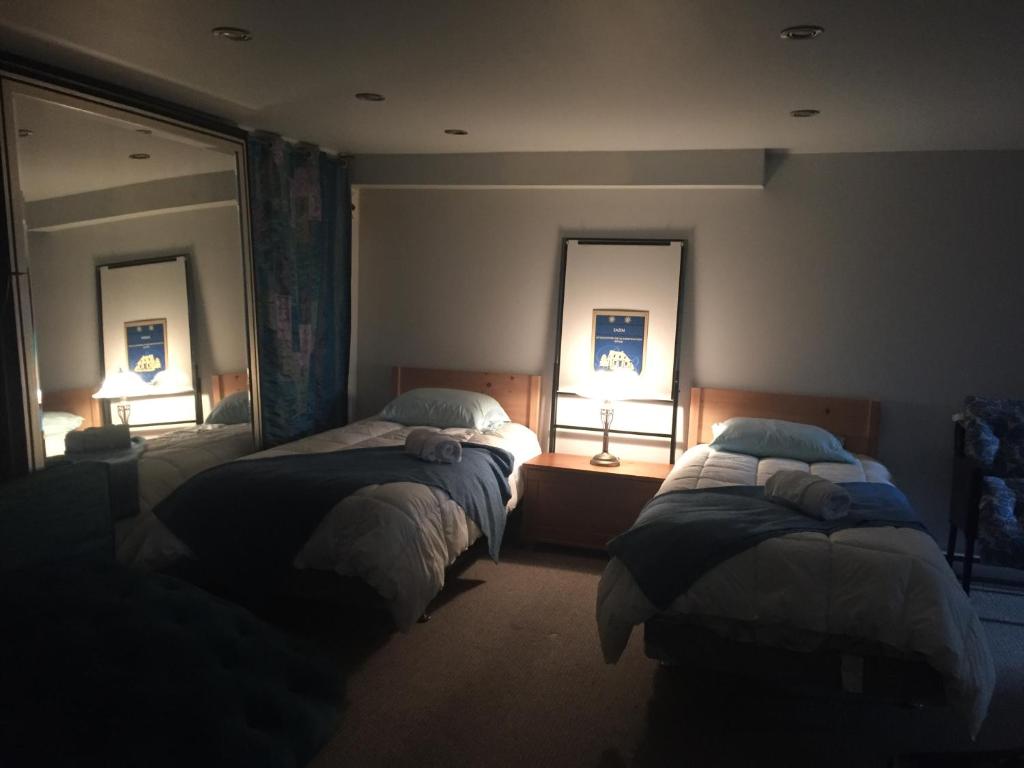 a bedroom with two beds and two mirrors at Gîte Zazen in Mont-Laurier