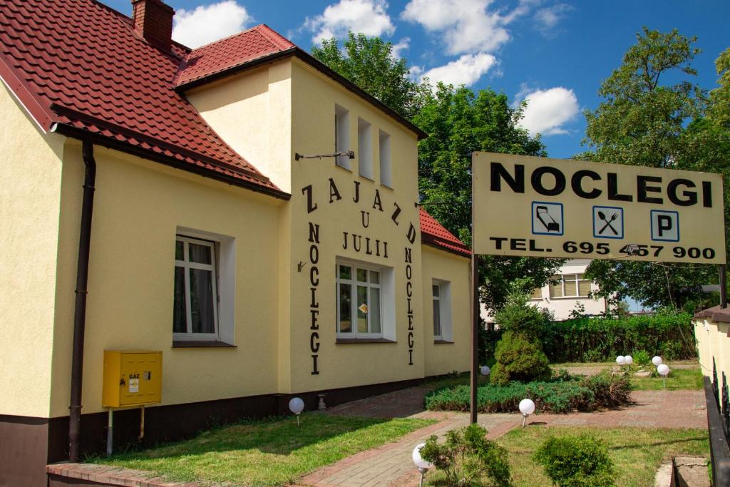un edificio con una señal frente a un edificio en Zajazd U Julii, en Miastko