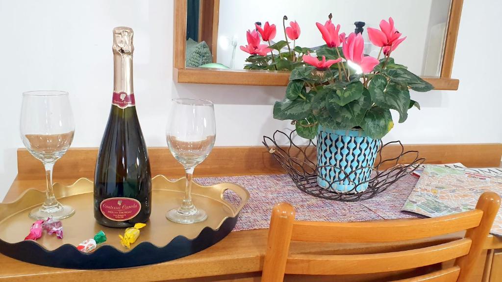 un tavolo con una bottiglia di vino e due bicchieri di A Casa Simpatia - Check-in Via Bixio, 41 a Roma