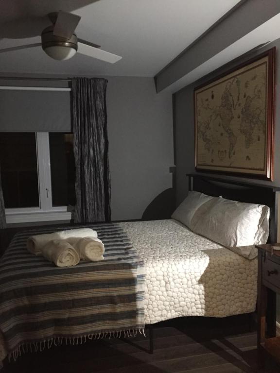 a bedroom with a bed with two towels on it at Gîte Zazen in Mont-Laurier