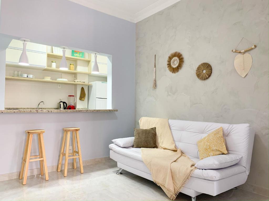 uma sala de estar com um sofá branco e dois bancos em Conforto em Copacabana- 100m da praia - BR1307 Z4 no Rio de Janeiro