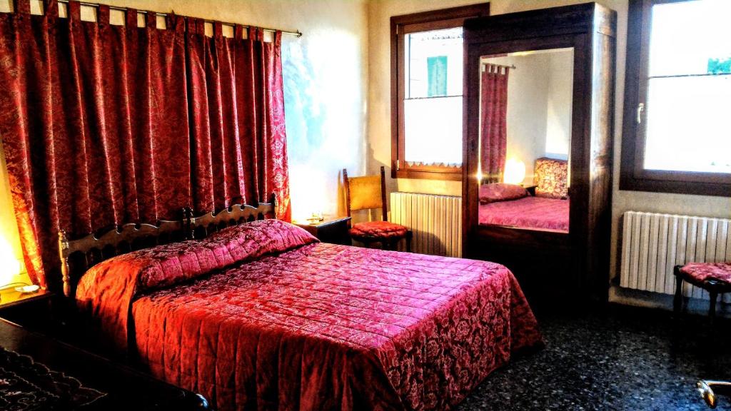 a bedroom with a red bed and a mirror at Appartamento 1749 Venicemar in Venice