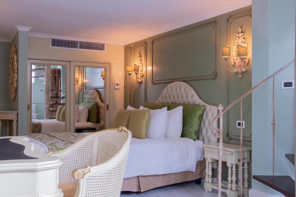 a bedroom with a white bed and a mirror at Villa Palma Boutique Hotel in Panama City