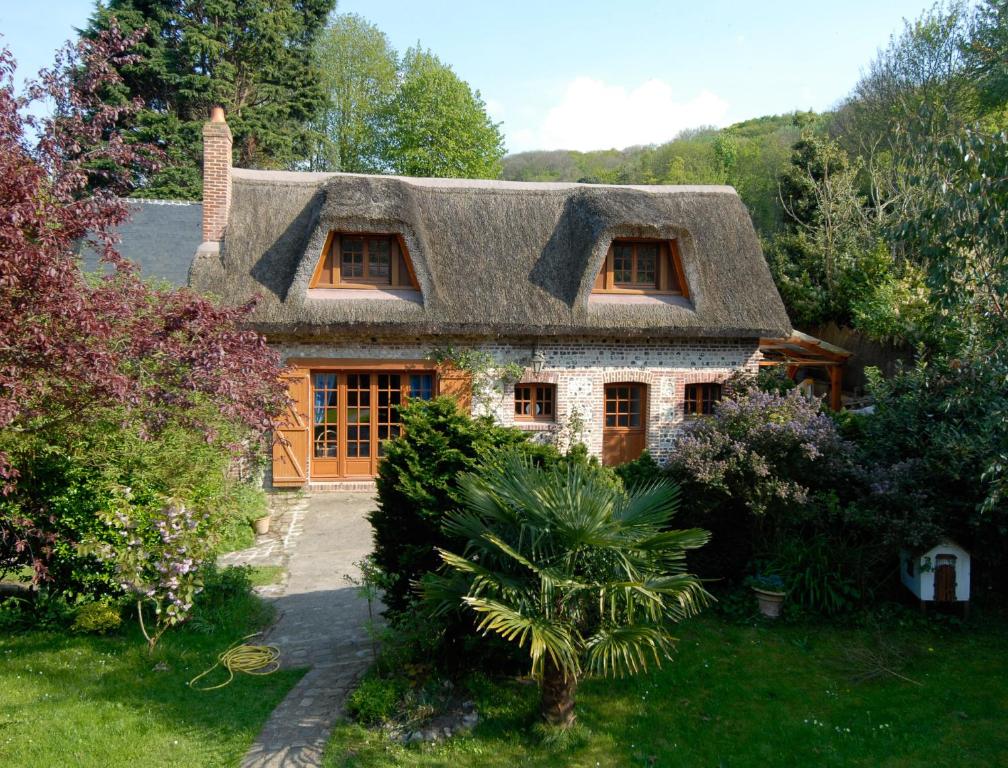 a house with a thatched roof in a garden at La Villa Flore in Saint-Jouin-Bruneval