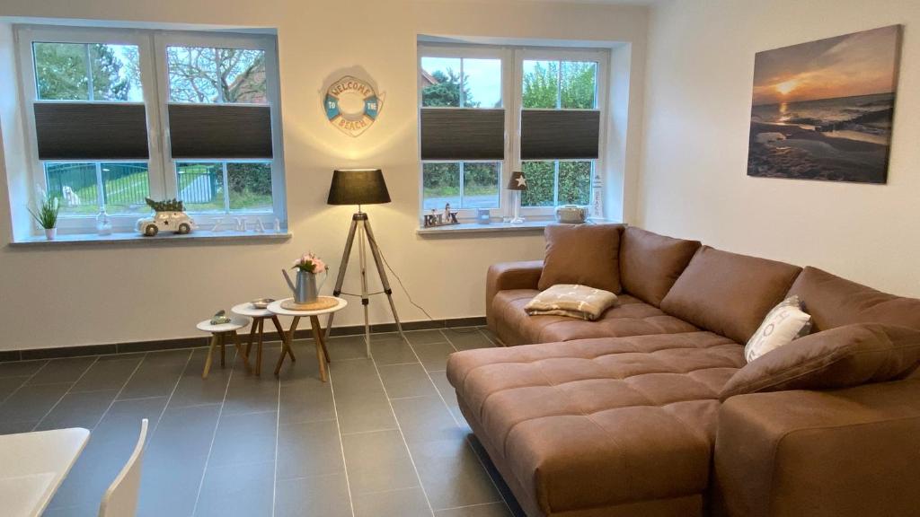 a living room with a brown couch and windows at Fewo Barth in Barth