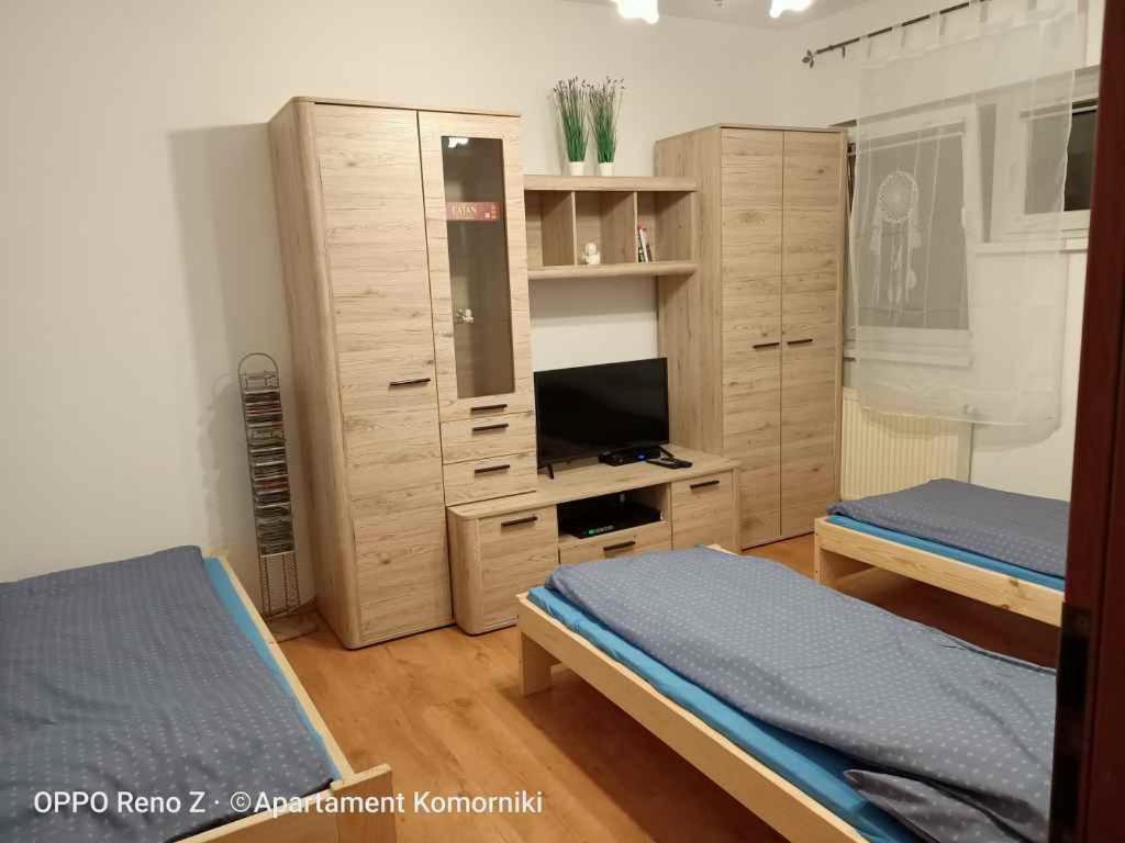 ein Schlafzimmer mit 2 Betten und ein Entertainment-Center in der Unterkunft Apartament Komorniki in Komorniki
