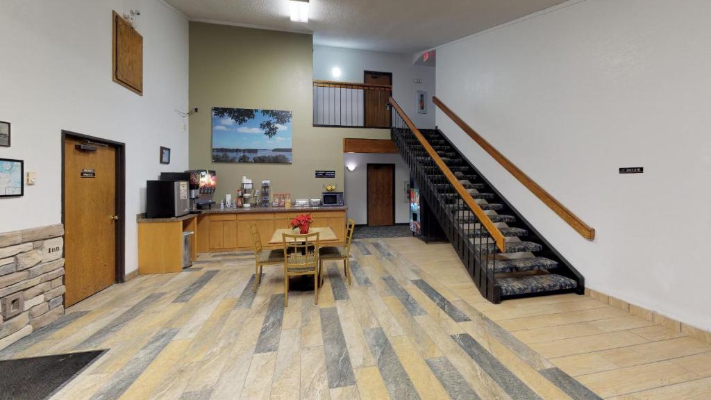 a lobby with a staircase and a table and a counter at Waconia Inn and Suites in Waconia
