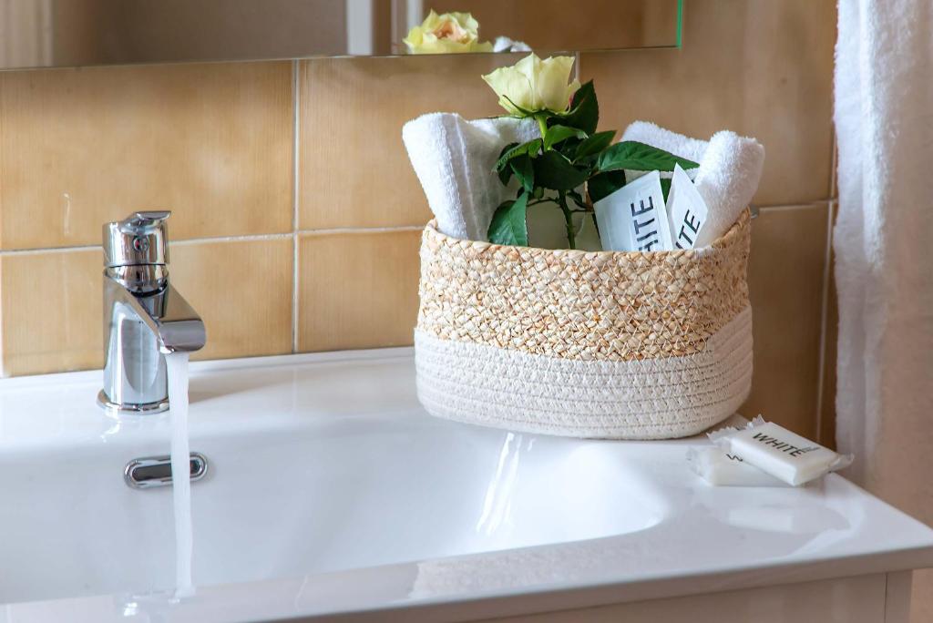 a basket of towels sitting on a bathroom sink at Plaza Rooms Ciampino in Ciampino
