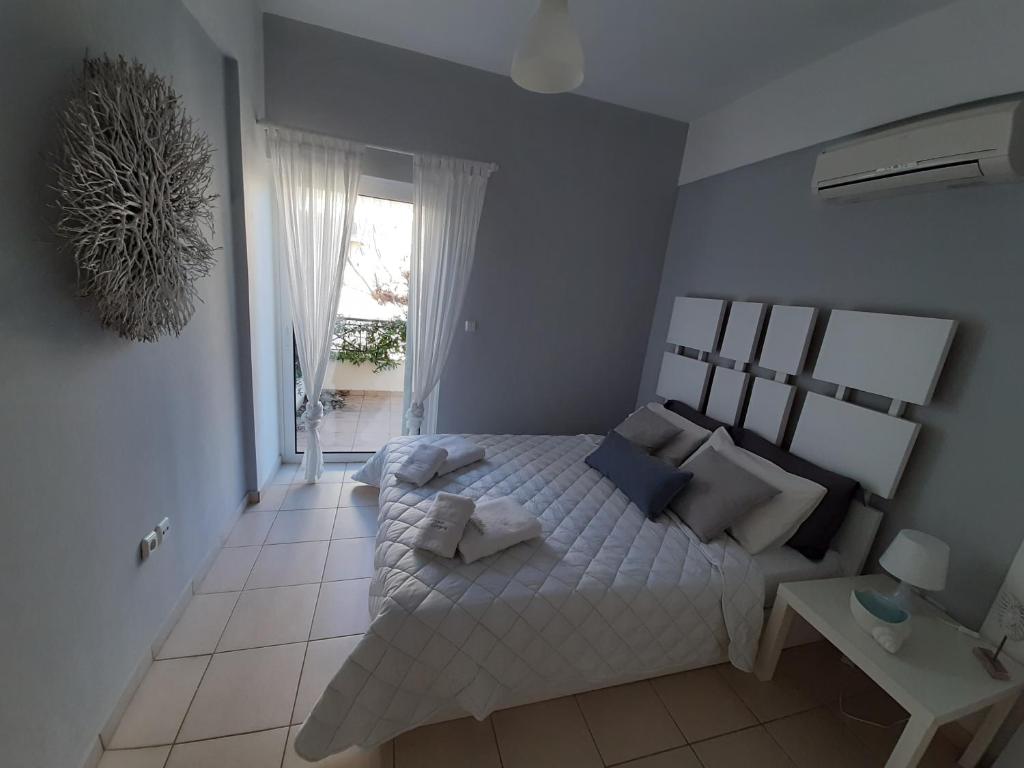 a bedroom with a large bed and a window at Miramar Complex - Korfos in Korfos