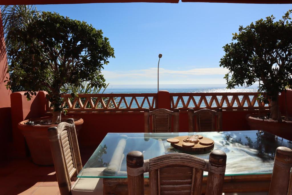 ein Tisch und Stühle auf einem Balkon mit Blick auf das Meer in der Unterkunft Penthouse Luxury Faro Casasol in Torrox Costa