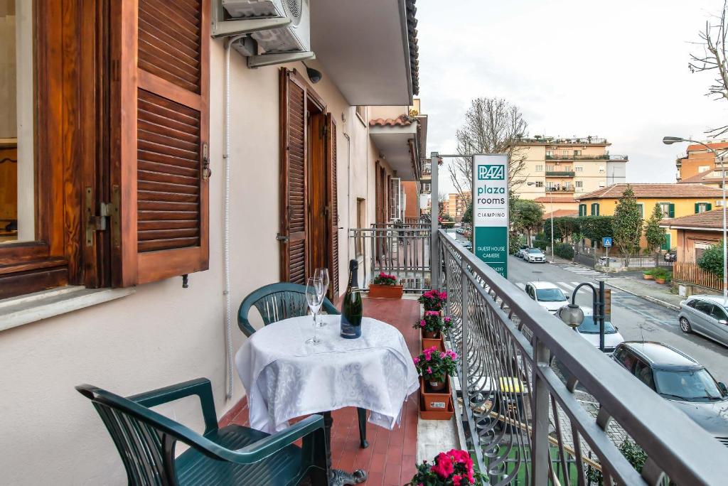 a balcony with a table and chairs and a street at Plaza Rooms Ciampino in Ciampino