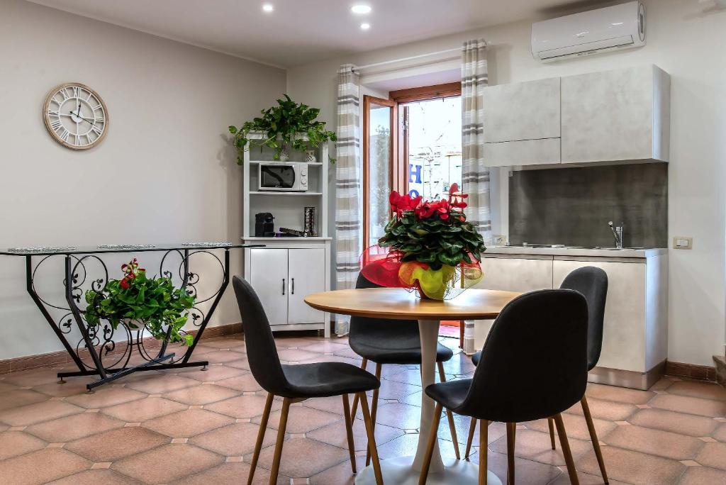 a kitchen with a table and chairs and a clock at Plaza Rooms Ciampino in Ciampino