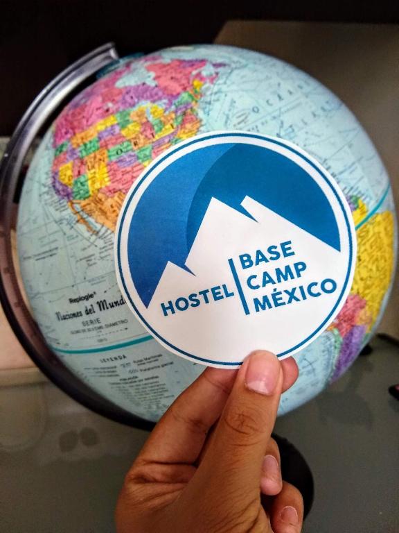 Eine Hand hält einen Ball mit einer Beschriftung auf einem Globus in der Unterkunft Hostal Base Camp México in Orizaba
