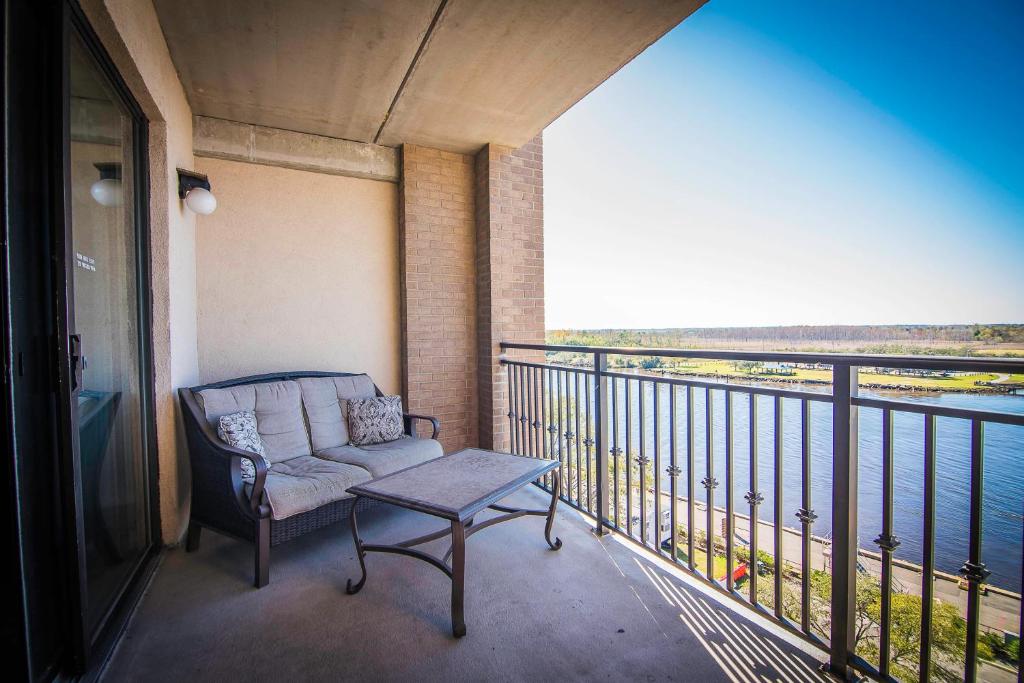 a chair on a balcony with a view of the water at Water Street Retreat 08 in Wilmington