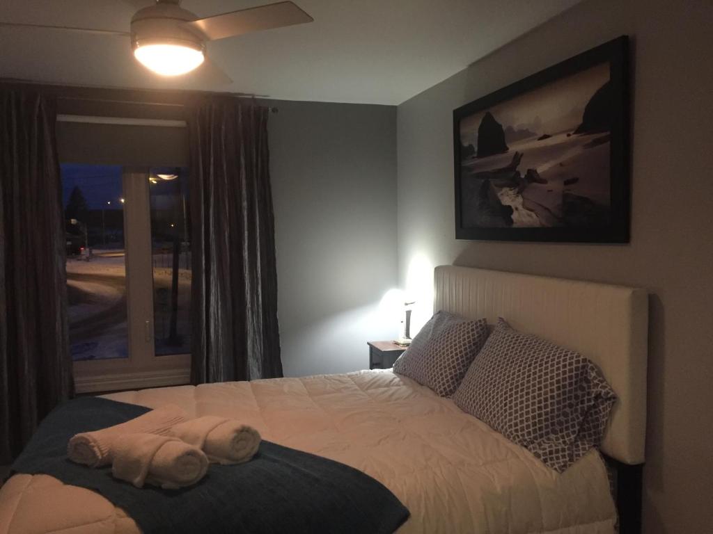a bedroom with a bed with a towel on it at Gîte Zazen in Mont-Laurier