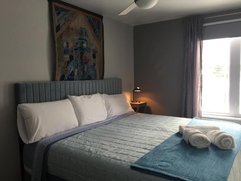 a bedroom with a bed with towels on it at Gîte Zazen in Mont-Laurier