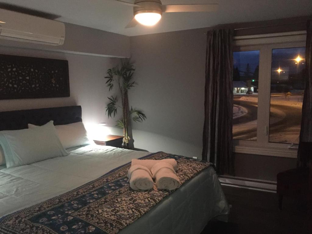 a bedroom with a bed with a pair of slippers on it at Gîte Zazen in Mont-Laurier