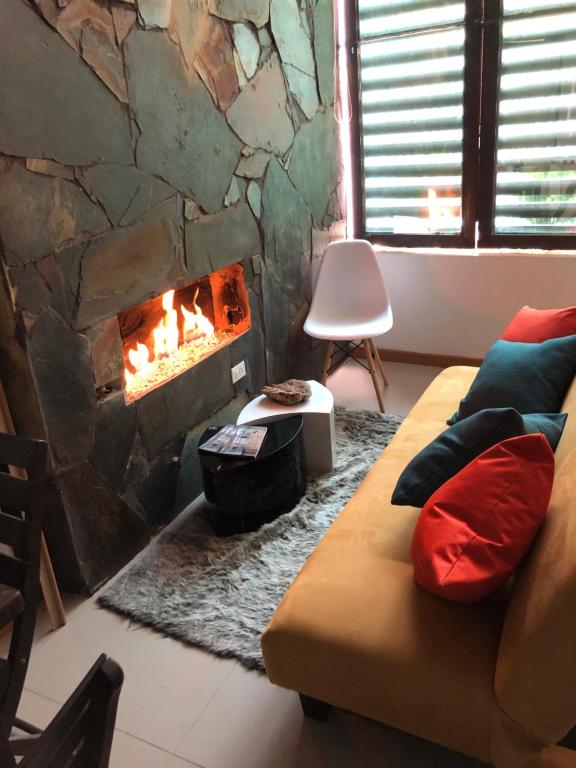 sala de estar con chimenea y sofá en ESTAR AQUI Bogotá, en Bogotá