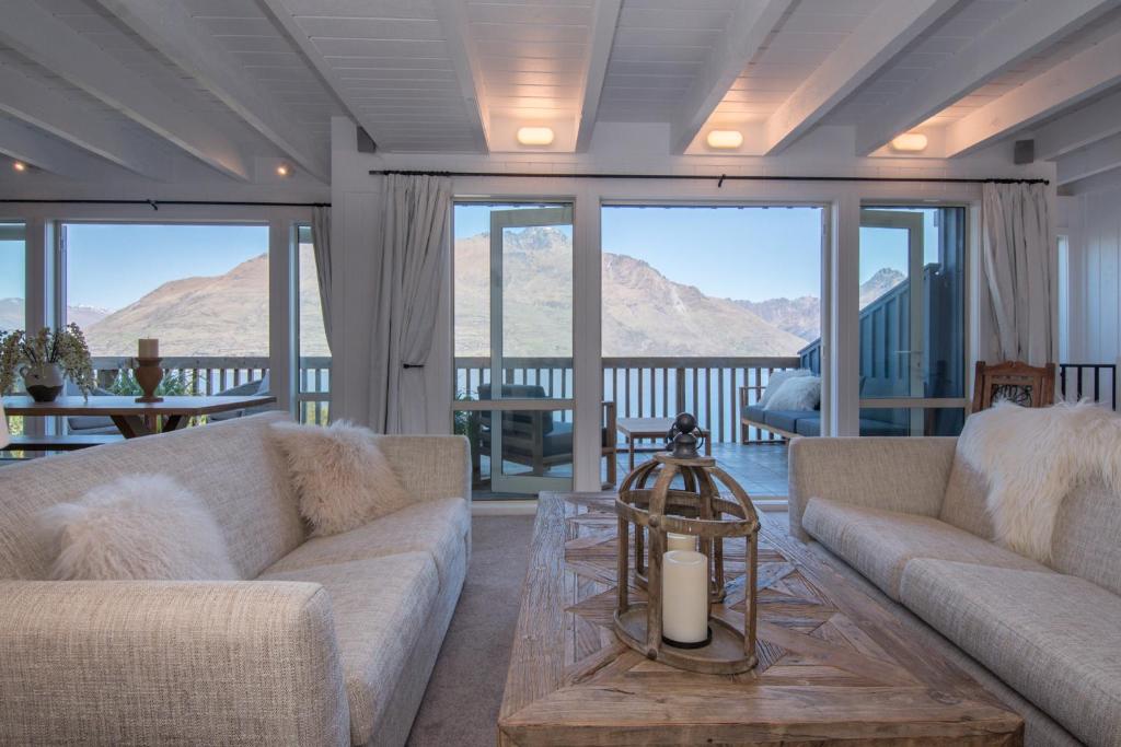 a living room with two couches and a table at The Alpine Way Queenstown in Queenstown