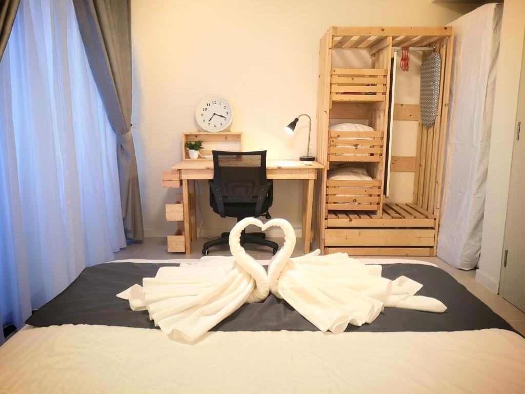 塞貝維的住宿－Tamarind Suites by BeeStay Management，一间卧室配有一张带心形毛巾的床