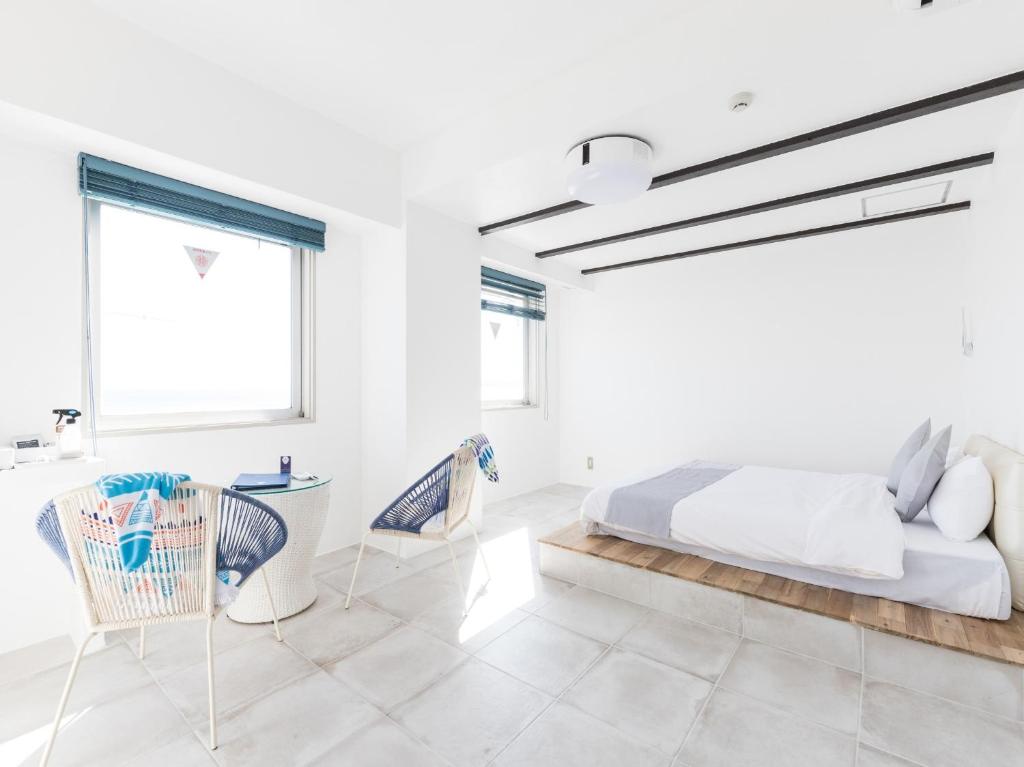 a white bedroom with a bed and two chairs at Mykonos Resort Miura / Vacation STAY 62180 in Yokosuka