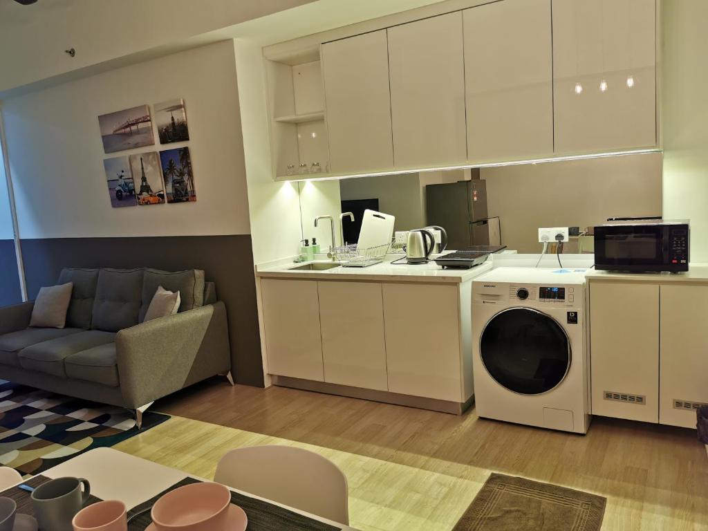 a kitchen and living room with a washing machine at REVO at AURORA PLACE, Pavilion 2, 5 Minutes To AXIATA ARENA BUKIT JALIL FREE WIFI by De Harlequins Guesthouse in Kuala Lumpur