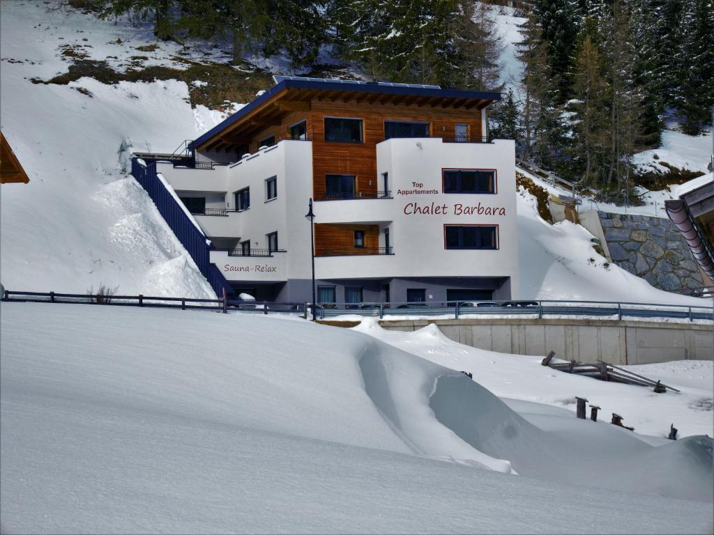 un edificio con una rampa de nieve frente a una pista de esquí en Chalet Barbara en Ischgl