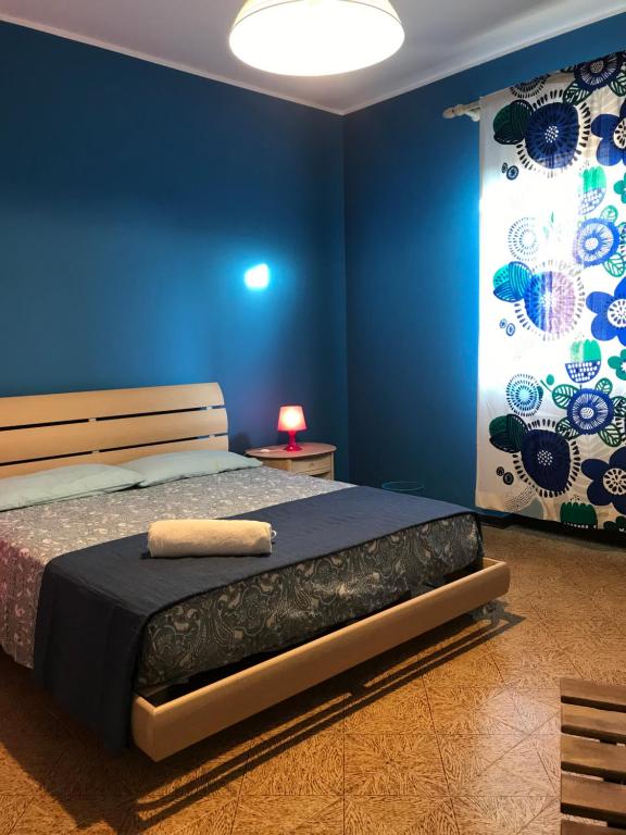 ein Schlafzimmer mit einem Bett mit einer blauen Wand in der Unterkunft Le sorelle gemelle B&B in Teramo