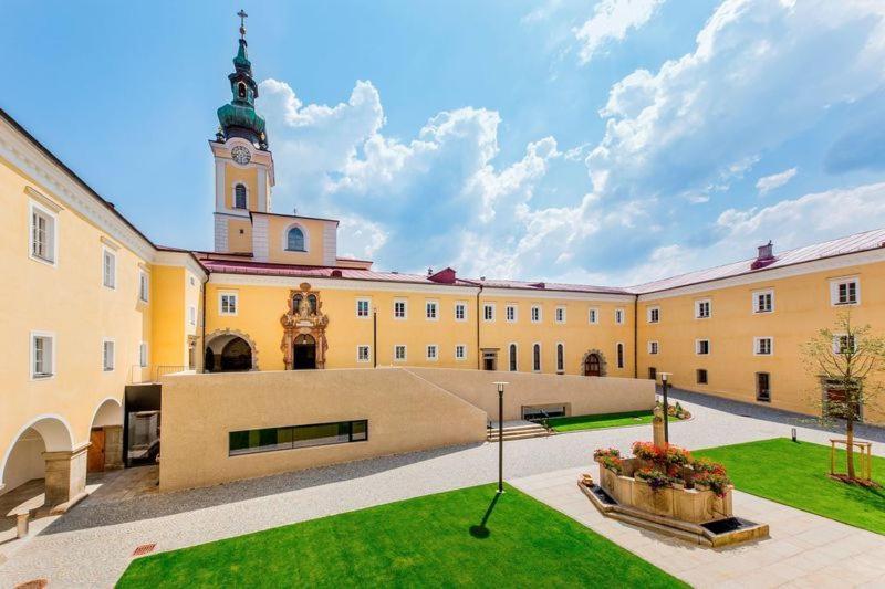 un grand bâtiment avec une tour d'horloge en haut dans l'établissement Seminarzentrum Stift Schlägl, à SchlÃ¤gl