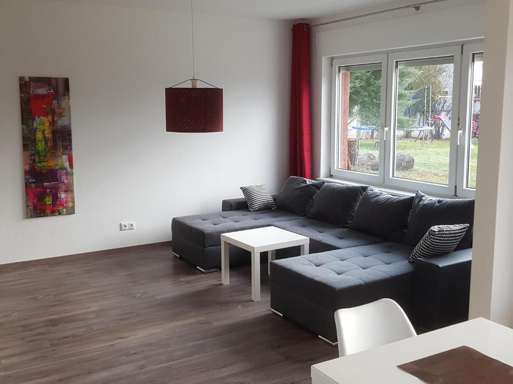 uma sala de estar com um sofá e uma mesa em Ferienwohnung Eyb em Ansbach