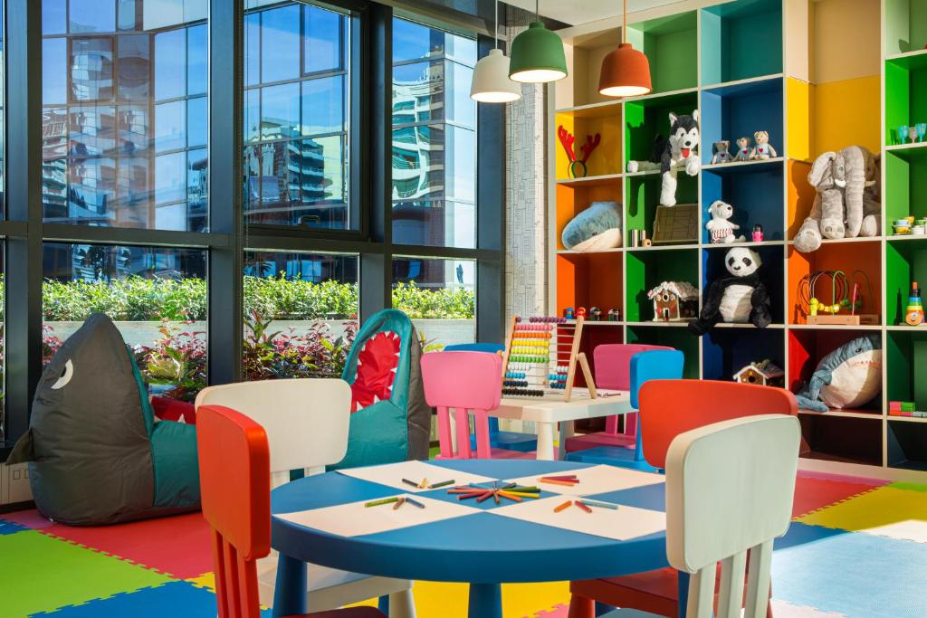 a childrens play area with a table and chairs at Millennium Place Barsha Heights Hotel in Dubai