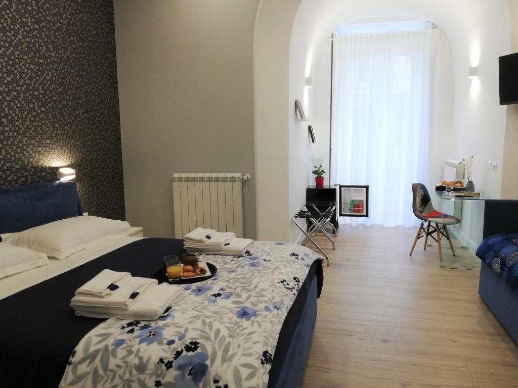 ein Schlafzimmer mit einem Bett mit einer blauen und weißen Decke in der Unterkunft Porta San Gennaro in Neapel