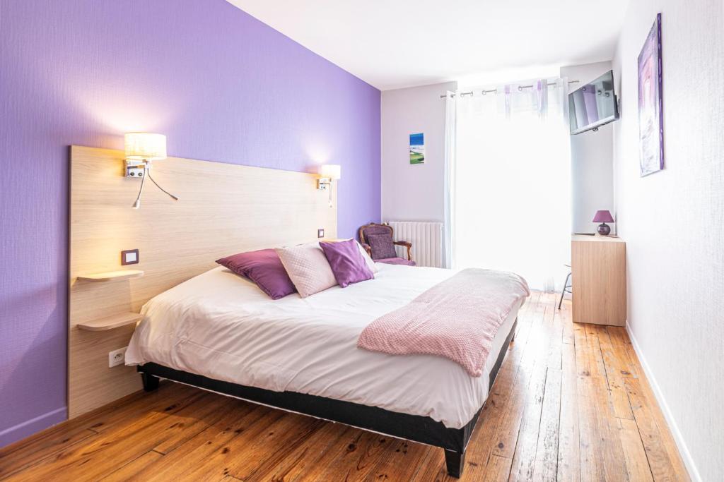 1 dormitorio con 1 cama con paredes moradas y suelo de madera en Hotel Helios - Golf, en Salies-de-Béarn