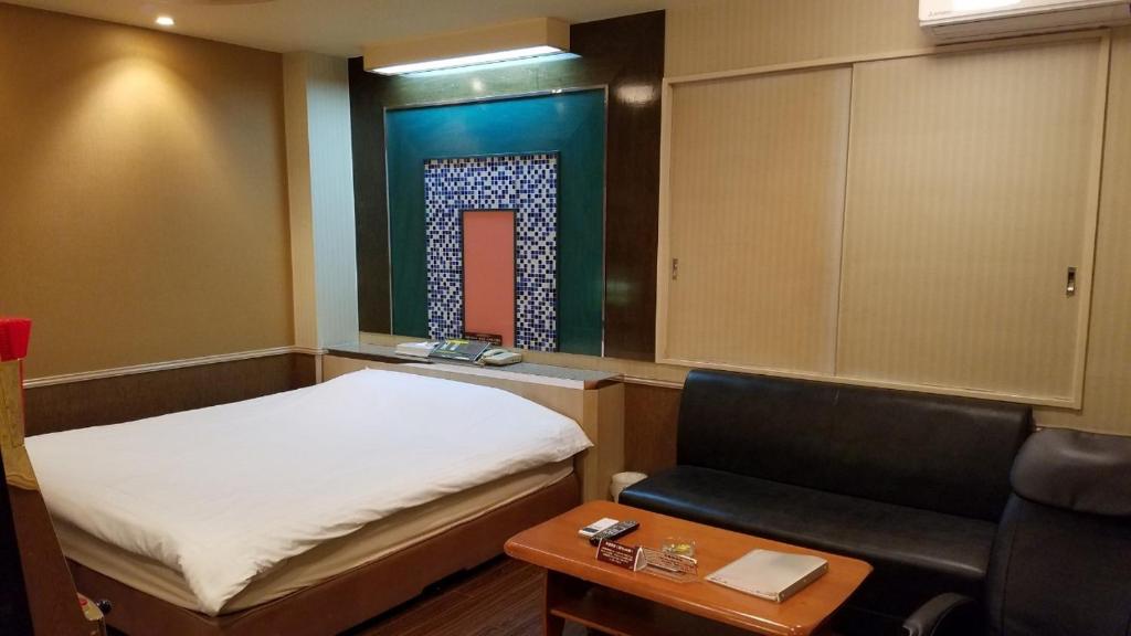 a small room with a bed and a chair at Hotel GOLF Yokohama (Adult Only) in Yokohama